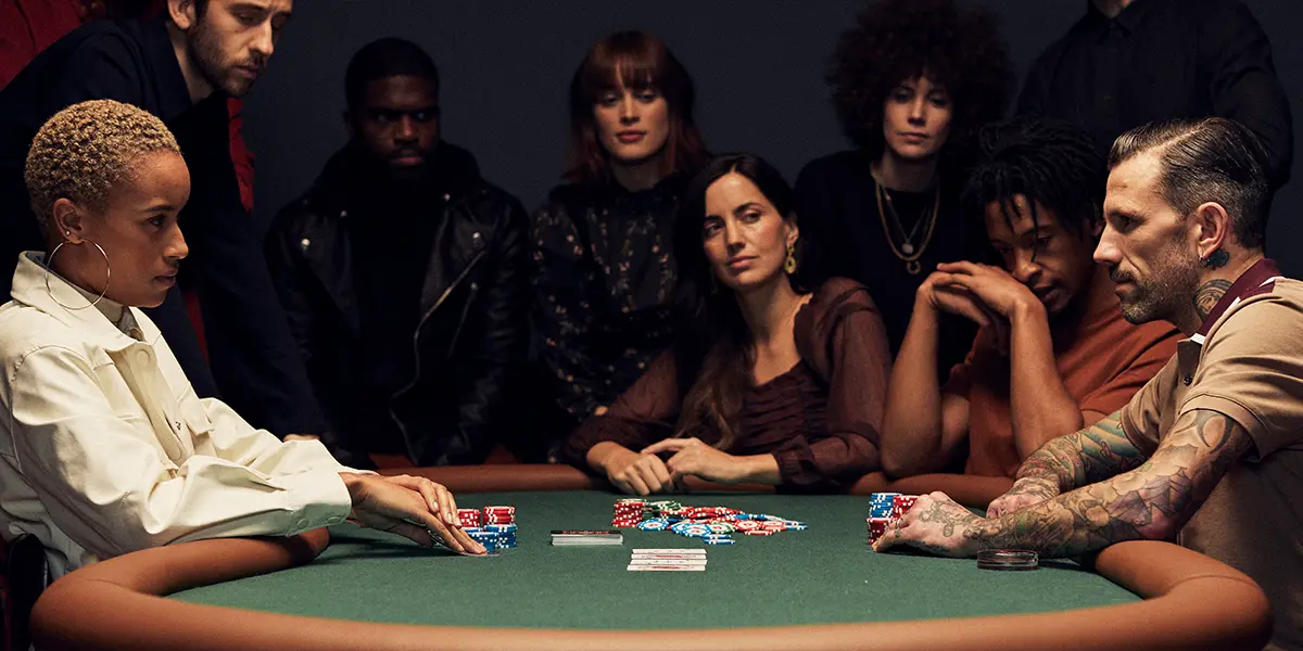 Poker player attempting a large bluff while opponents study the board carefully