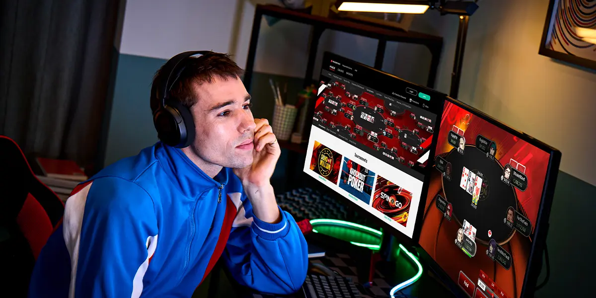 Professional player analyzing poker opponents on dual monitors.