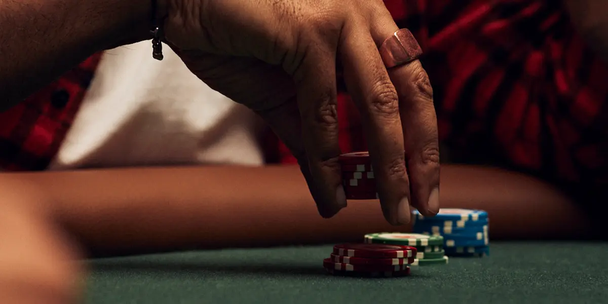 A poker player placing a small bet, demonstrating small bet-sizing.