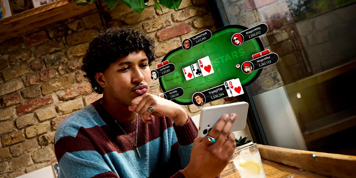 A poker player focused on playing a multi-table tournament (MTT) on PokerStars using a mobile phone.