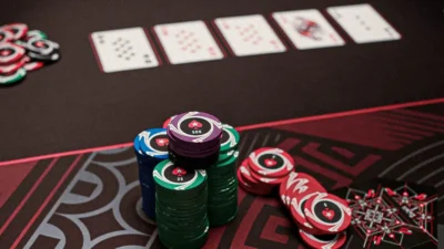 Large poker chip stack and community cards on a table.