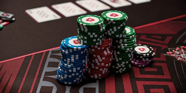 Close-up of poker chips and cards on a felt table during a mixed game