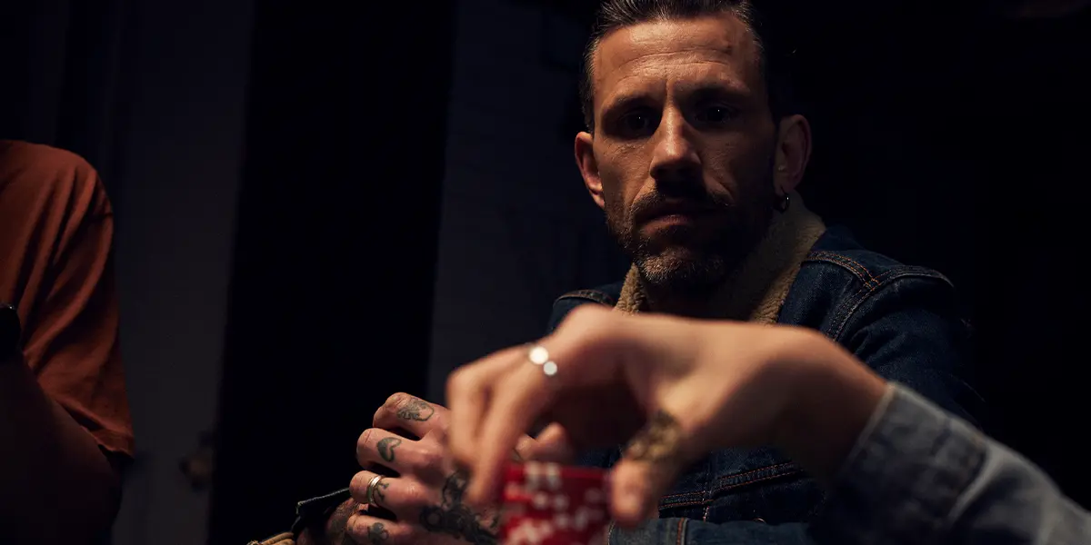 Focused poker player watching opponents to gather reads and betting patterns.